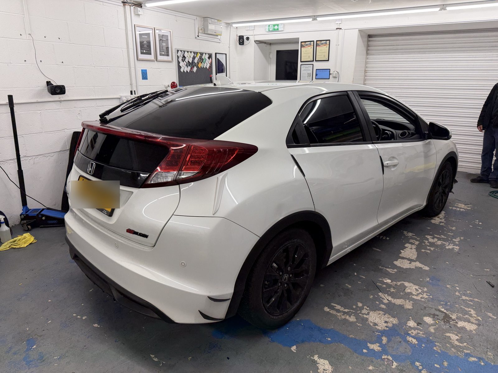 White Honda Civic with tinted rear windows in the workshop
