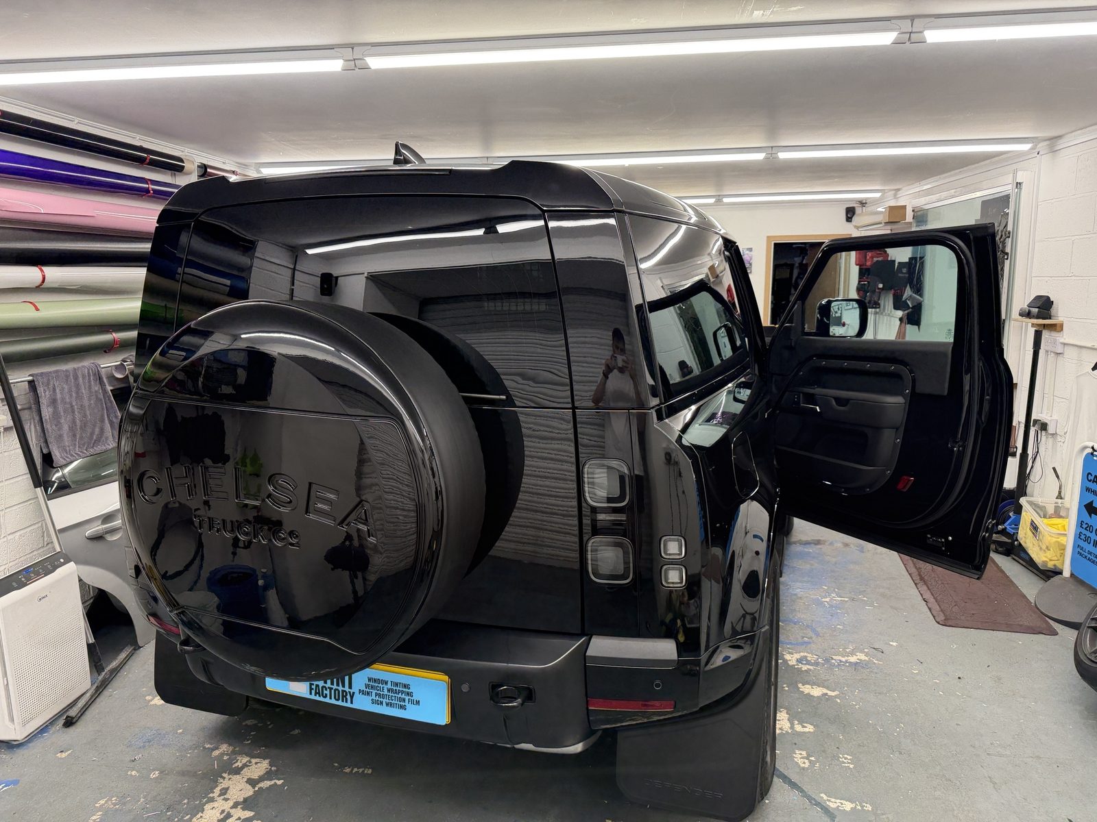 Black Land Rover Defender with tinted rear and side glass in the workshop