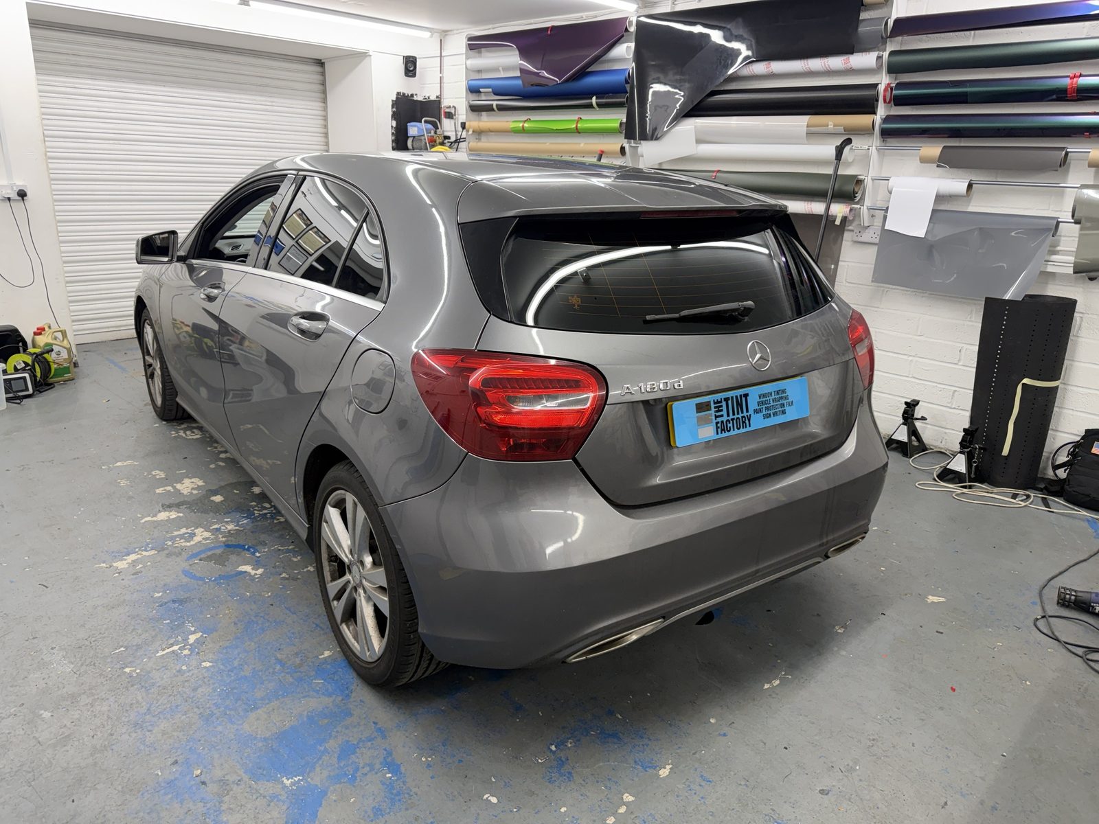 Grey Mercedes A-Class with tinted rear windows in the workshop